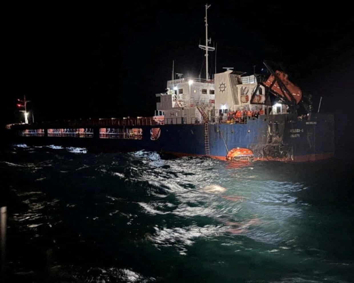 A ship damaged by a drone strike sits at sea at night in the Black Sea