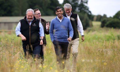 Britain’s Prime Minister and Conservative Party Leader Rishi Sunak walks with Cotswolds Distillery founder Dan Szor (L) Conservative candidate for Stratford-on-Avon Chris Clarkson (2L) and Cotswolds Distillery founder Jeremy Parson (R).