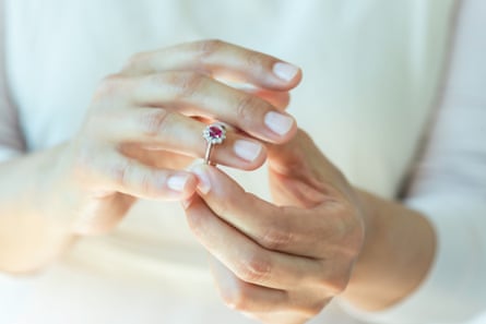 Seorang wanita meletakkan cincin ruby di jarinya