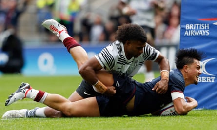 England's Marcus Smith beats Fiji's Lekima Tagitagivalu to score a try.