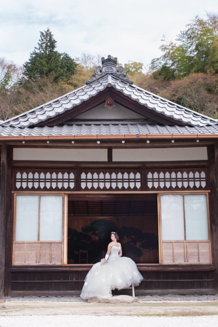 Naomi Harris in a wedding dress sitting in a pagoda in a Japanese garden