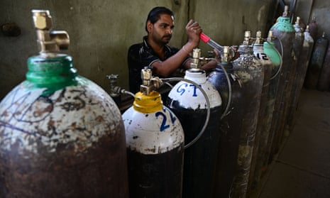 A worker refills an oxygen cylinder bought by family members of COVID-19 patients at a factory in Uttar Pradesh, India.