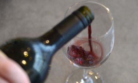pouring red wine from a bottle into a wine glass