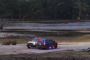 two police vehicles idle on a road