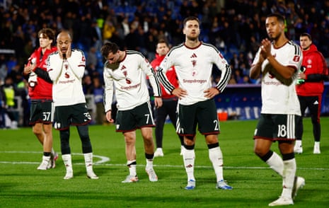 Manchester United players look dejected on the pitch after the match