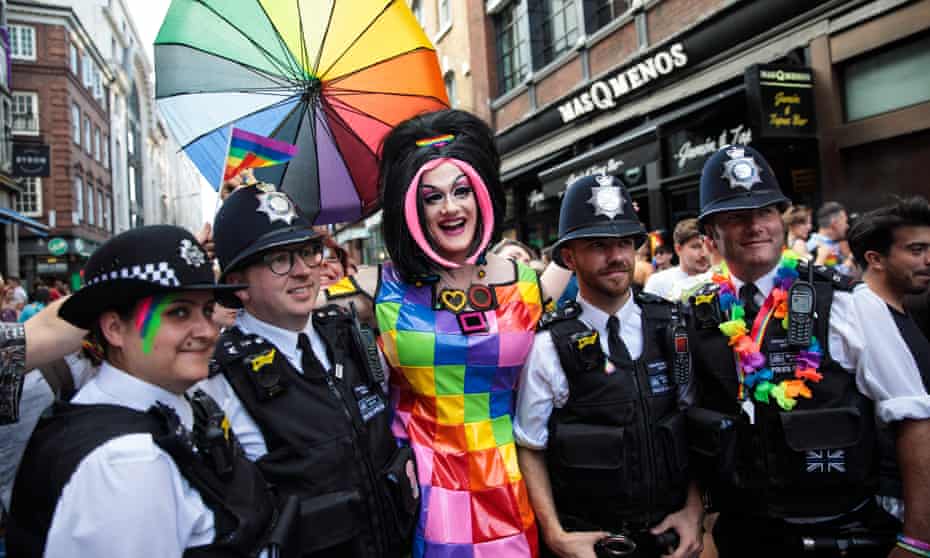 Police officers pose for a photograph with a reveller during the London Pride parade in 2017