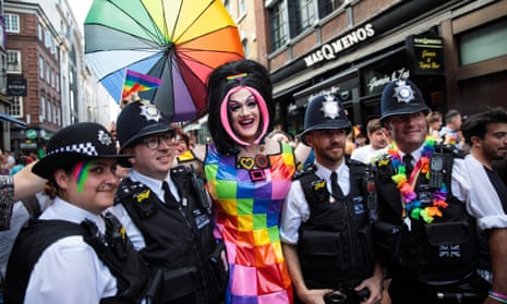 Police officers pose for a photograph with a reveller during the London Pride parade in 2017