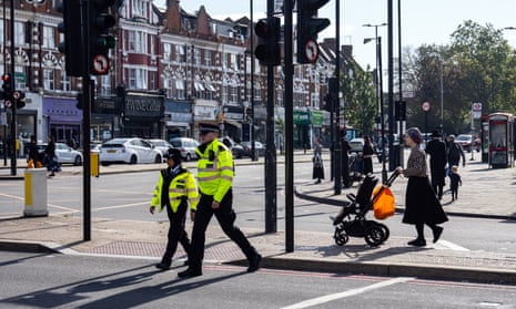 Police officers patrol through Stamford Hill, an area of London with a large Jewish community