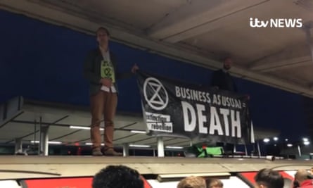 Des manifestants de la rébellion Extinction sur le toit d'une rame de métro