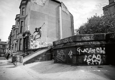 A person skating down a ramp at the side of a building