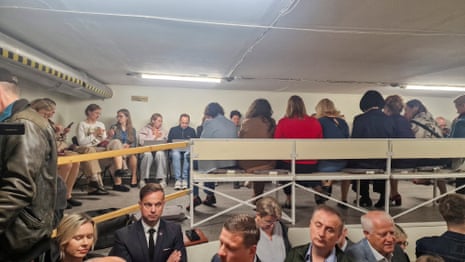 People gather inside a shelter at the Lithuanian parliament after an 'air danger' warning, in Vilnius, Lithuania.