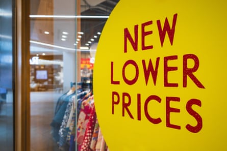 Bold Yellow Sign in Retail Store Window Advertising New Lower Prices