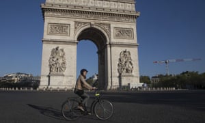 A woman rides a bike as she crosses the empty Place Charles de Gaulle in Paris, during the nationwide lockdown.