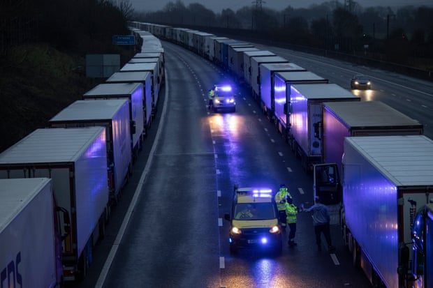 The coastguard give out bottles of water as lorries queue on the M20 on December 21, 2020 in Sellinge, England
