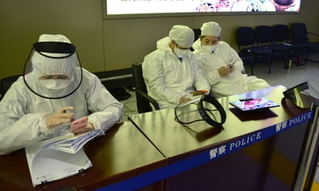 Workers in protective suits at an airport in Harbin, capital of Heilongjiang province bordering Russia, where coronavirus quarantine restrictions are in place