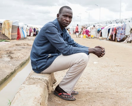 Portrait of Tut Dador sitting on a stone block in the Renk transit centre in South Sudan