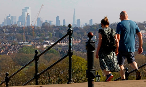 A couple take in the view of London walking in Alexandra Park.