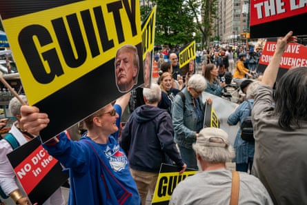 Smiling crowds holding signs that say Guilty.