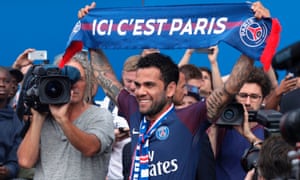 Dani Alves poses with a scarf after a press conference in Paris.