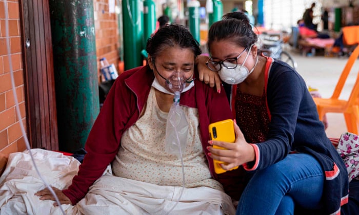 A COVID-19 patient breathing with the assistance of oxygen and her daughter talk to relatives through a mobile phone at the regional hospital in Iquitos, the largest city in the Peruvian Amazon, on 9 May 2020 during the novel coronavirus pandemic.