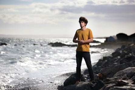 Caspar Lampkin, project officer for coastal paths, standing on the rocky shore.