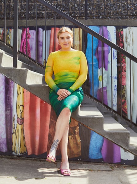 Annie Lord sitting on steps wearing a bright yellow tops and dark green steps.