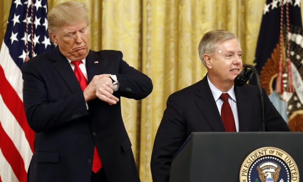 Donald Trump pretends to check his watch as Senator Lindsey Graham speaks at the White House in November.