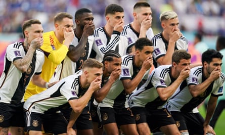 Duitse spelers houden hun mond voor hun teamfoto voor hun wedstrijd tegen Japan
