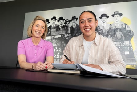 Manuela Zinsberger signs a contract next to Svenja Schlenker.