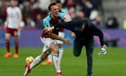 Mark Noble clashes with a fan who has invaded the pitch during West Ham’s defeat by Burnley in 2018.