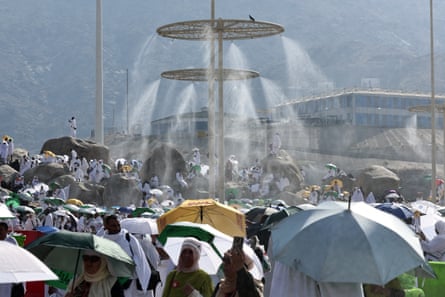 Mist dispensers above a large crowd of pilgrims