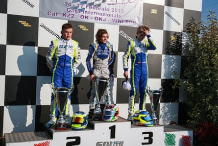 Andrea Kimi Antonelli stands atop a karting podium with trophies alongside two other young drivers