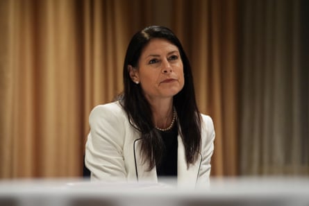 Dana Nessel, dressed in a white suit and black shirt, appears to be sitting.