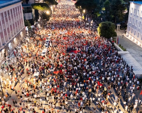 A drone view shows thousands of protesters carrying banners, placards, and Albanian flags in central Tirana, Albania.