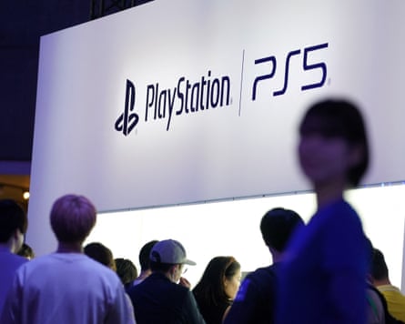 People looking at a PLayStation PS5 sign at an event
