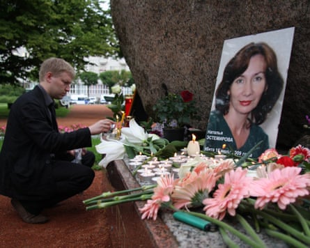 A Russian man lights a candle in front of a portrait of killed Chechen human rights activist and journalist Natalia Estemirova in St Petersburg, Russia, in 2009.