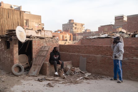 Yassin, right, and one of his roommates on the roof of their apartment block, where the phone signal is strongest.