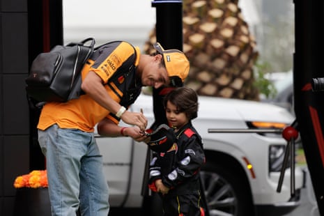 Lando Norris signs an autograph for a young fan