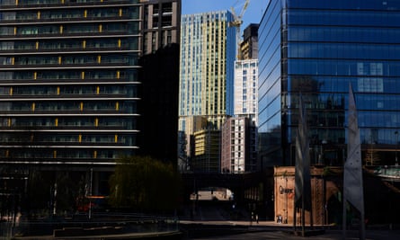 View of modern office blocks and flats in a city centre, with the sun illuminating the ones in the background