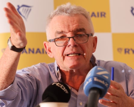 Michael O'Leary gestures while speaking into microphones at a press conference