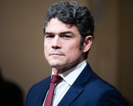 a man in a suit looks ahead