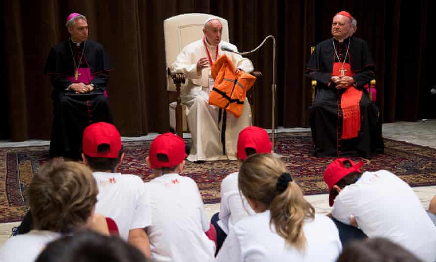 Pope Francis holding the life jacket of a young victim drowned in the Mediterranean sea trying to reach Europe.