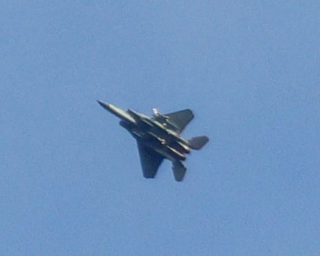 एक लड़ाकू जेट नीले आकाश के सामने खड़ा है।