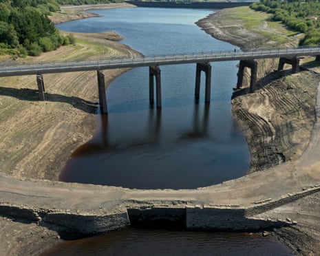 Aerial view of a bridge over Baitings Reservoir, its banks exposed by drought-lowered water