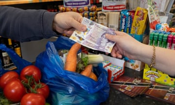 hands passing money for a bag of vegetables to a shop keeper