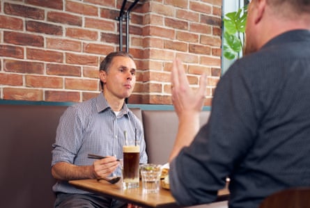 Celestino sat at the table as seen from behind Miles.
