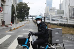 Delivery worker for Alibaba’s Hema Fresh chain rides his electric bicycle on a road following an outbreak of the novel coronavirus in Wuhan.