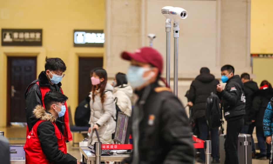 Passengers at Hankou Railway Station in Wuhan in central China’s Hubei province go through infrared detectors at Hankou Railway Station in Wuhan in central China’s Hubei province as workers check for coronavirus symptoms