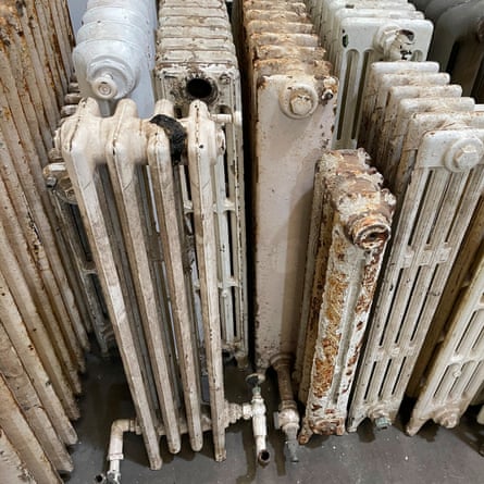 Image of old fashioned cast iron radiator collection stored in reclamation yard warehouse, focus on foreground
