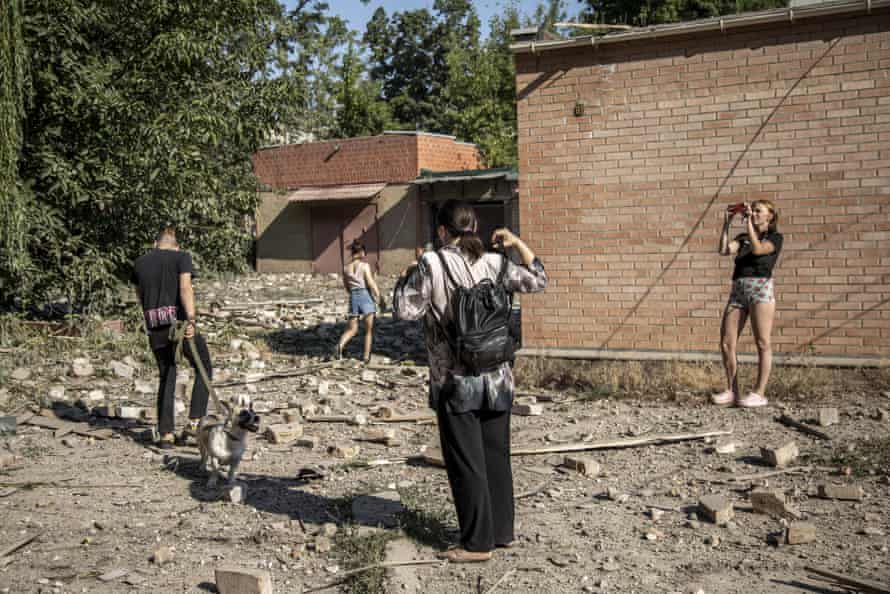 Local civilians take photos in a damaged civilian neighbourhood in Bakhmut.